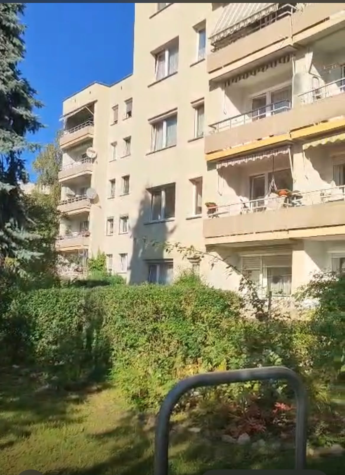 Widok na jasną elewację budynku mieszkalnego z balkonami w Opolu